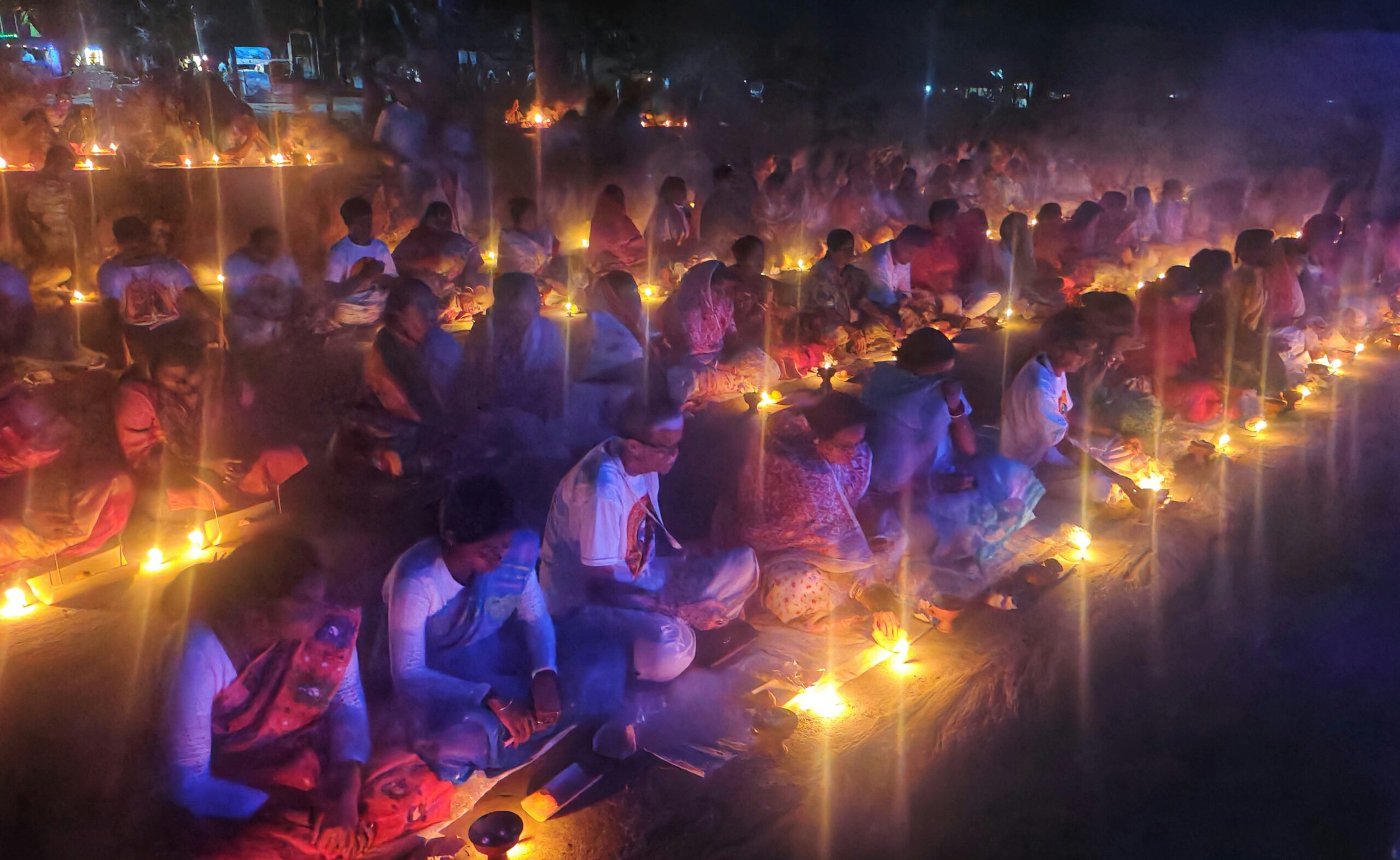A large group of people sitting around candles